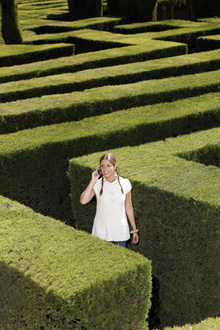 Eine Frau telefoniert in einem Labyrinth